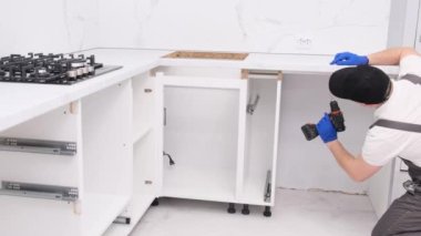 The furniture installer uses a modern electric doiler with lighting. Apartment renovation concept. 4k video