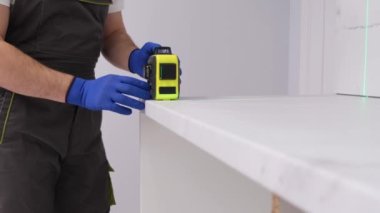 The furniture installer uses a modern multi-level laser. Apartment renovation concept. 4k video