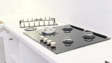 A gas service worker repairs a gas stove. A man repairs a stove in the kitchen. 4k video