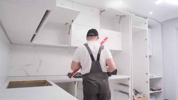 サービス技術者は 水位を使用して台所に継手をインストールします 高品質4Kビデオ — ストック動画