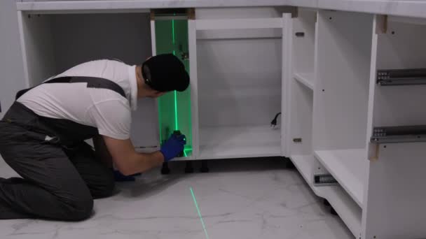 Master Installs Furniture Kitchen Room Using High Precision Construction Laser — Vídeo de Stock