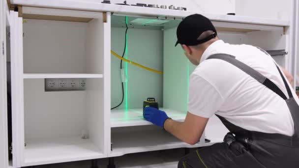 Pekerja Menginstal Furnitur Ruang Dapur Master Menggunakan Tingkat Laser Elektronik — Stok Video
