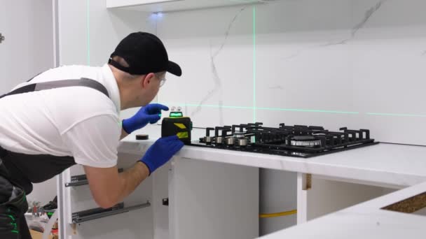 Worker Installs New Gas Stove Measures Laser Renovation New Building — Vídeo de stock