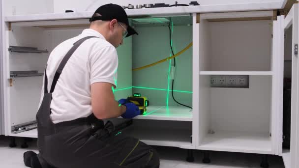 一名专业的工匠将使用高精度的施工激光在厨房安装家具 家庭翻新概念 — 图库视频影像