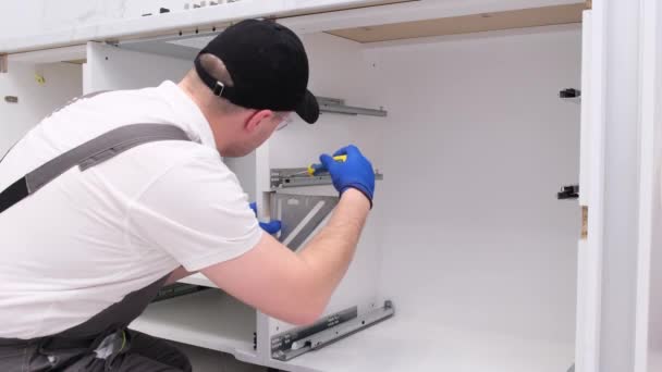 Professional Craftsman Installs Furniture Kitchen Using Screwdriver Location Drawers Bedside — Video Stock