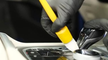 Close-up, employees professionally clean a dirty car with a brush. Professional car wash.