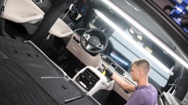 A car service worker washes a car with chemicals. Modern car interior cleaning. 4k video