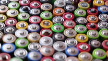 A large number of used batteries, which are evenly stacked in the plane. Rotation around the circle of finger batteries.