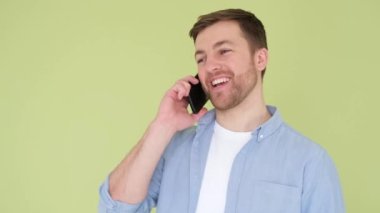 The guy with a nice appearance speaks gently on the phone and laughs. Pleasant emotions. Joy