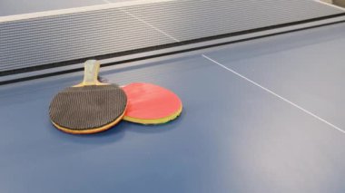Equipment for playing ping-pong. Rackets and ball on a blue table for table tennis. Sport.