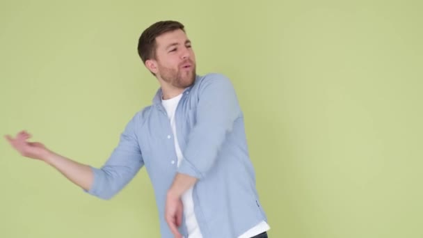 青いシャツを着たカメラのハンサムな男に炎症を起こすダンス 気分がいい 広告撮影 — ストック動画
