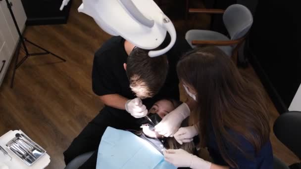 Процес Стоматологічного Лікування Чоловічий Стоматолог Асистент Лікують Зуби Допомогою Сучасних — стокове відео