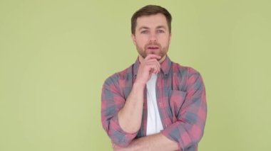 Confident, serious young man puts his hand under his chin. A gesture of confidence. Poolyad of confidence