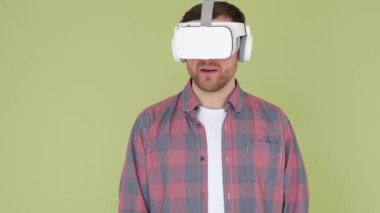 Infinitely joyful, happy, surprised young man in virtual reality glasses. Emotions of an attractive guy. The concept of modernity