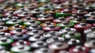 Macro image of a group of colored batteries rotating in a circle. Processing of hazardous waste.