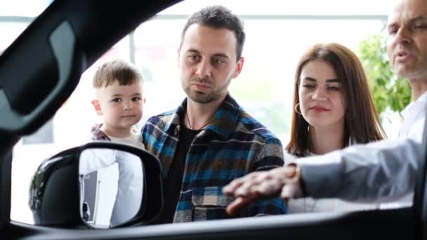 Sales Manager Presents Good Car Purchase Young Family Inspection Cars — Αρχείο Βίντεο