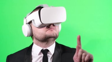 A virtual player swipes a finger on a touchscreen phone, smartboard. A man in a business suit on a green background. Businessman of the future. Virtual reality