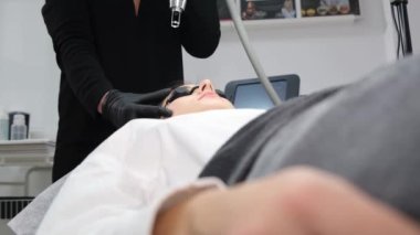 A young girl in a beauty salon in protective glasses. Laser facial hair removal procedure using modern technologies