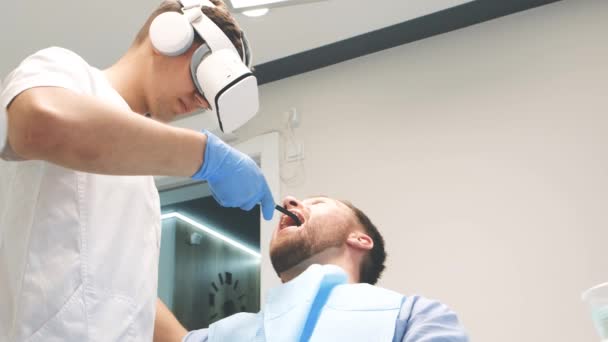 Modern Dental Clinic Doctor Treats Teeth Using Virtual Reality Glasses — Vídeo de Stock
