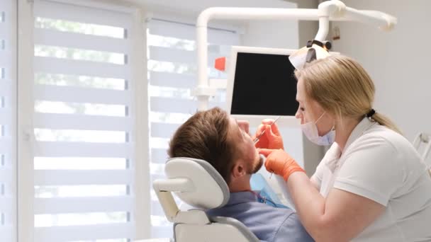 歯医者が人の歯を検査する 歯科治療の概念 星の除去 クリーニングを運びます アメリカの近代歯科学 — ストック動画