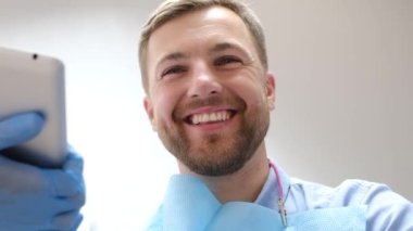 A dentist examines a patient with instruments in a dental clinic. The doctor performs dental treatment in a modern clinic. Painless dental treatment