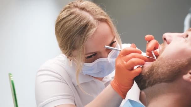 Dentystka Bada Zęby Młodego Mężczyzny Siedzącego Krześle Dentystycznym Stomatologia Wyrównanie — Wideo stockowe