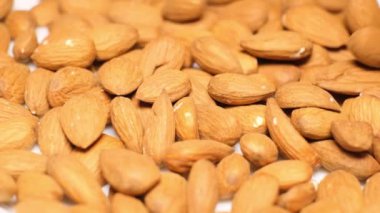 Bademlere yakın çekim. Sarı arka plan. Mineral ve vitamin açısından zengin bir ürün. Arkaplan olarak badem yığını.