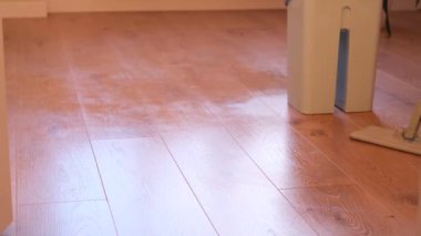 Cleaning the floor from dust using a hand mop for washing. Advertisement of a restaurant company.