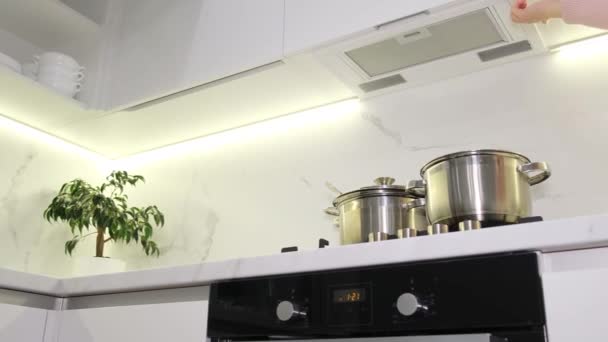女手按下按钮打开厨房炉子上的通风 蒸汽进入厨房的盖子 — 图库视频影像