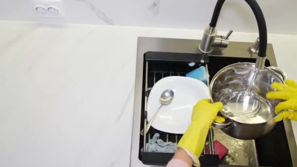 一个女人用橡胶手套和海绵洗金属罐 女人用水洗锅 然后用肥皂擦拭锅 用海绵开始工作 — 图库视频影像