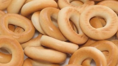 Macro video of dry durum wheat flour bagels spinning, delicious round tea bagels. 4k video
