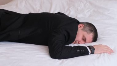 Genç bir adam yatakta yatarken alarm boyunca uyudu. Adam işe geç kaldı. 4k video