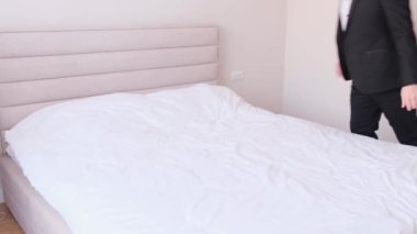 A tired business man goes to bed, he wants to sleep after a working day. A tired person goes to sleep. 4k video