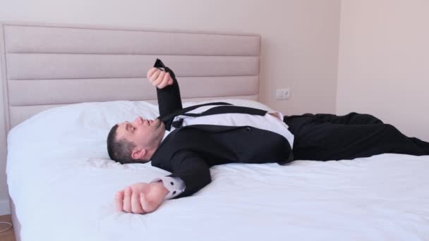 ヨーロッパの実業家は寝そべっている間に目覚まし時計を通した その男は仕事で遅れている — ストック動画