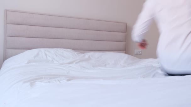 カラフルなウィッグを着たビジネスマンがベッドに横になっている 事務所のパーティだ 4Kビデオ — ストック動画