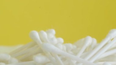 Rotating cotton swabs on a yellow chromakey background. Hygiene products. 4k video