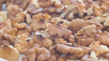 Peeled walnuts macro video. Walnut kernels fall into a stack during production. 4k video