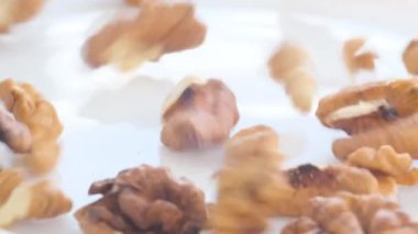 Falling into a plate of shelled walnuts in large quantities. Peeled walnut. Natural product. Slow motion