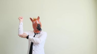 Mola sırasında at maskeli bir ofis çalışanı işte dans ediyor. Bir adam tarafından yapılan komik bir dans. Yavaş çekim