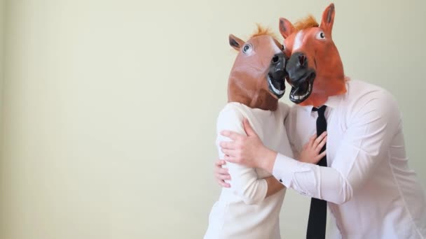 楽しい馬のマスクを着ている面白いカップル 家族のカップルが抱き合っている 彼らはカーニバルのマスクを着ている — ストック動画