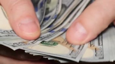 Makro video, 100 dolarlık banknotları erkek eliyle sayıyor. 100 dolarlık banknotlar sayılıyor. İş kavramı, finans. 4k video