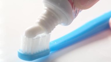 Applying toothpaste to a toothbrush macro video. Dental care concept. Advertisement of toothpaste