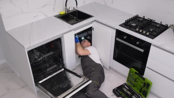 Male Plumber Fixing Broken Dishwasher Plumbing Services Usa Video — Stockvideo