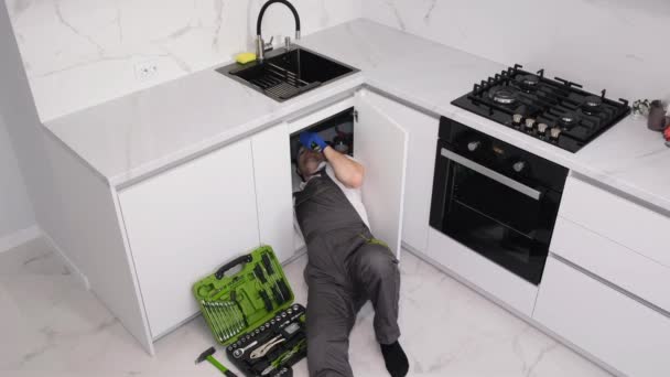 Ein Männlicher Klempner Repariert Eine Spüle Zum Geschirrspülen Für Eine — Stockvideo