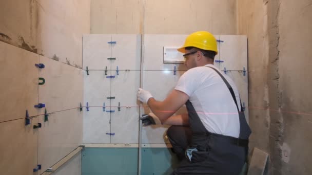 在浴室整修期间 建筑工人把瓷砖铺好 主人在尺子的帮助下把瓷砖平铺好 — 图库视频影像