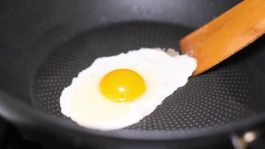 Bir yumurta kızartma tavasına kırılır ve kızarmış yağla tatlandırılır. Yumurta tavada yüksek kenarlı bir tavadan kızarır. Kapat.