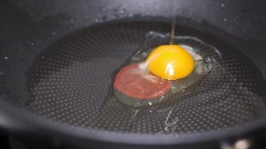 A close-up of a fried egg in a cast-iron pan during cooking. Slow motion 240fps.