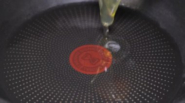 Slow motion, the egg is broken into a pan and fried over low heat. Preparing breakfast. Close up