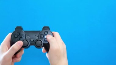 Playing computer games on a chromakey background. Game control with a video game console. Addiction to games, lifestyle, adolescence. Blue screen. 4k video