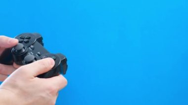 Hands of a man playing a game on a console on a blue chromakey background. 4k video